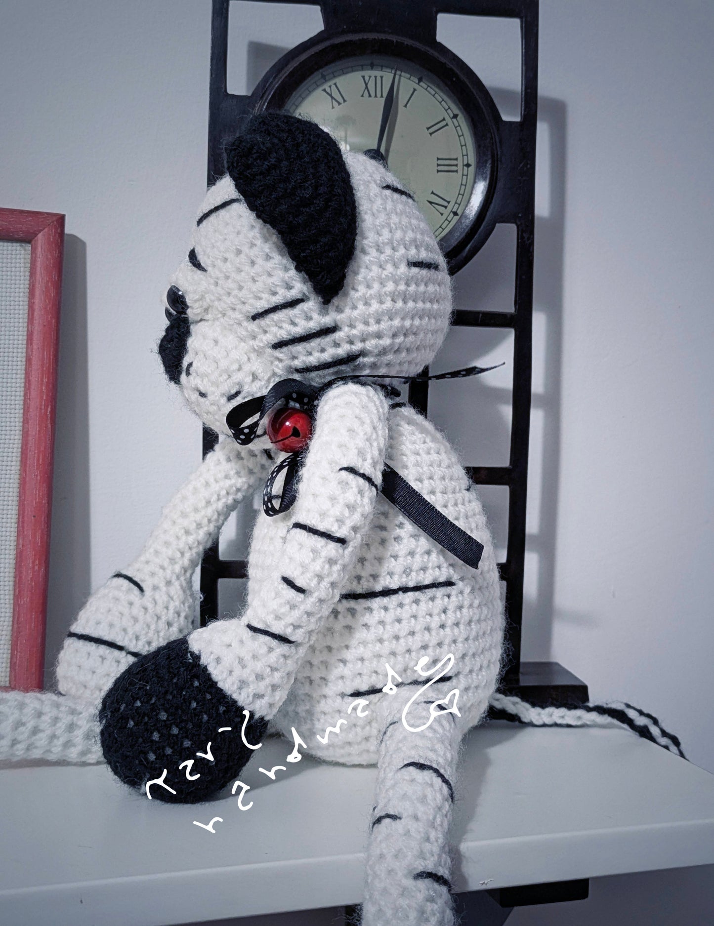 Pupazzo crochet Zigra – Pantera stilizzata in bianco e nero con sonaglio e nastro pois